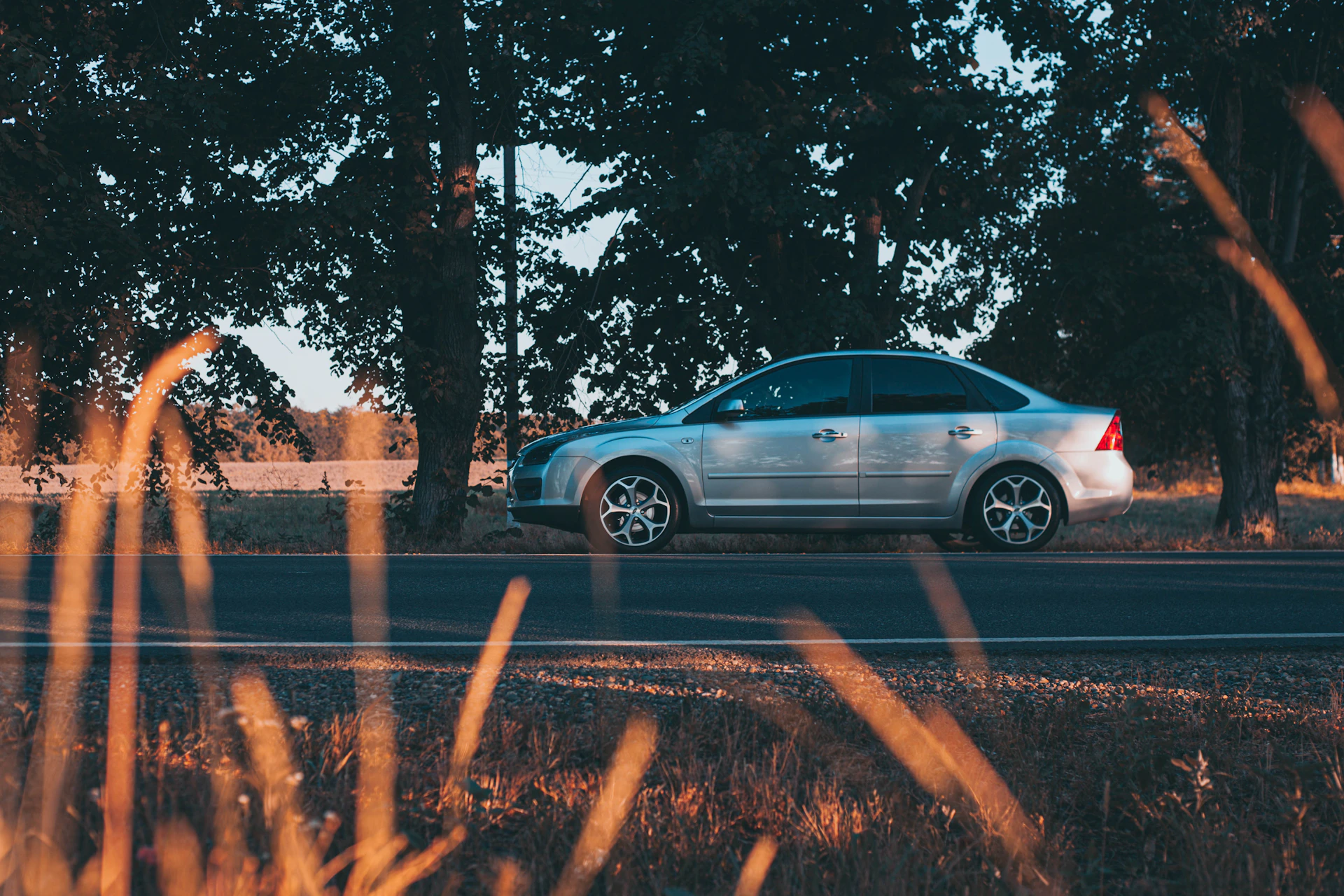 blue sedan on road during daytime