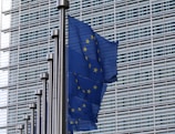 blue flag on pole near building during daytime