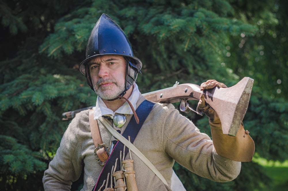 man in green and brown long sleeve shirt holding brown and black rifle