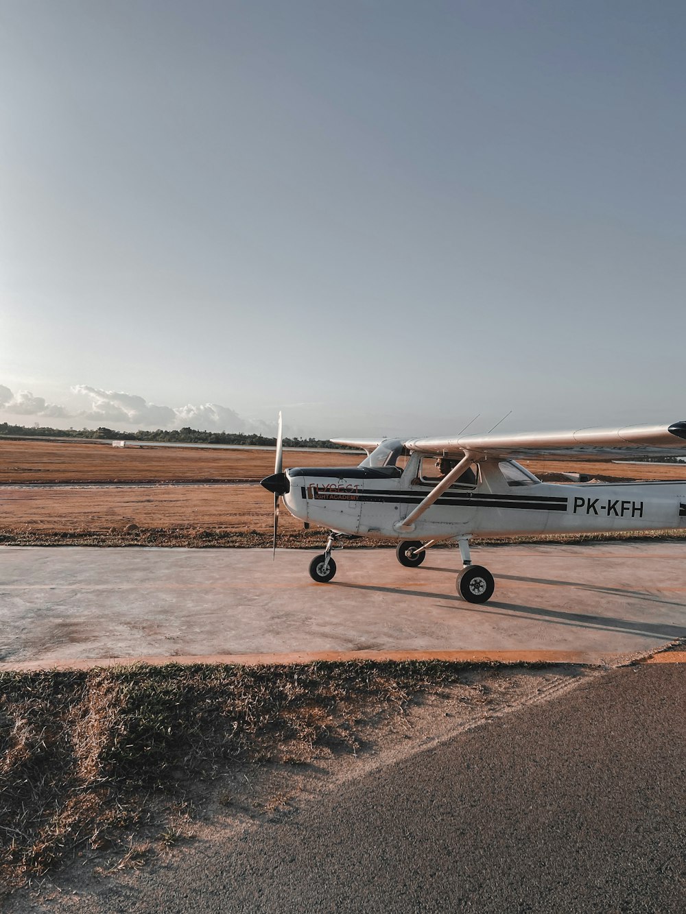 white and red airplane on brown field during daytime