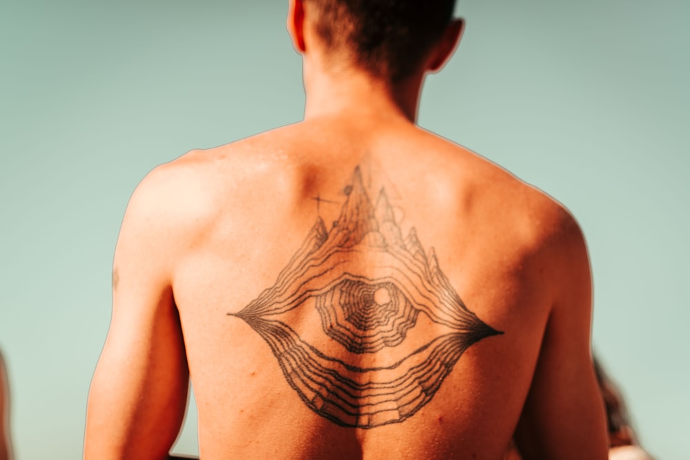 man with black tattoo on back
