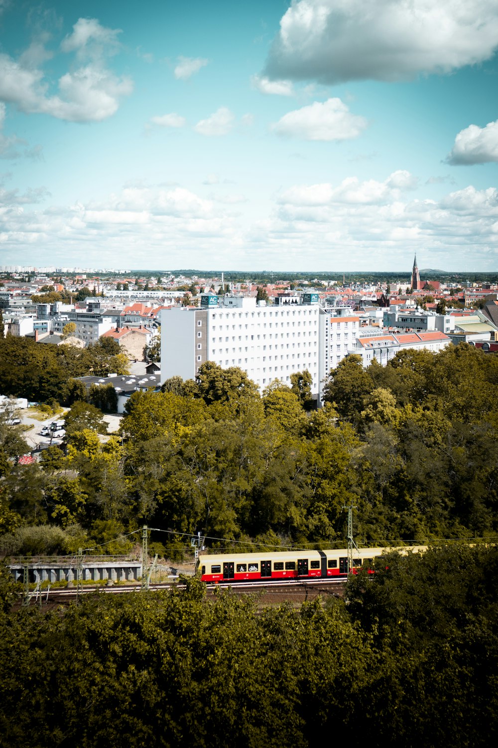 Train blanc et rouge sur rail près des bâtiments de la ville pendant la journée