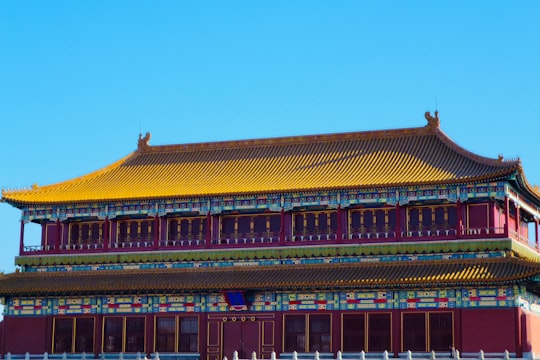 red and brown building under blue sky during daytime in The Palace Museum China