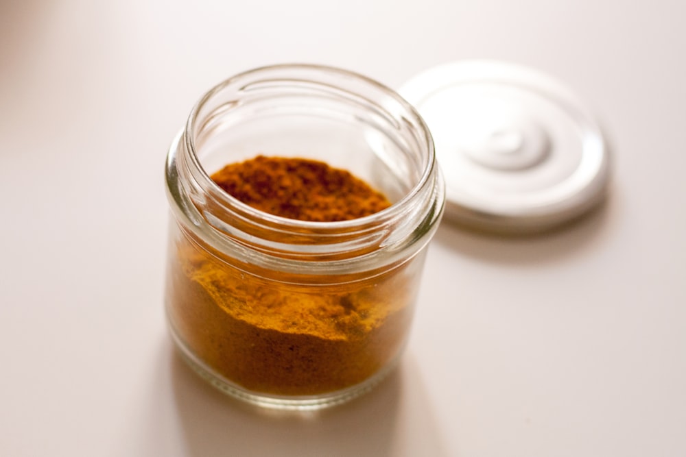 clear glass jar with brown powder