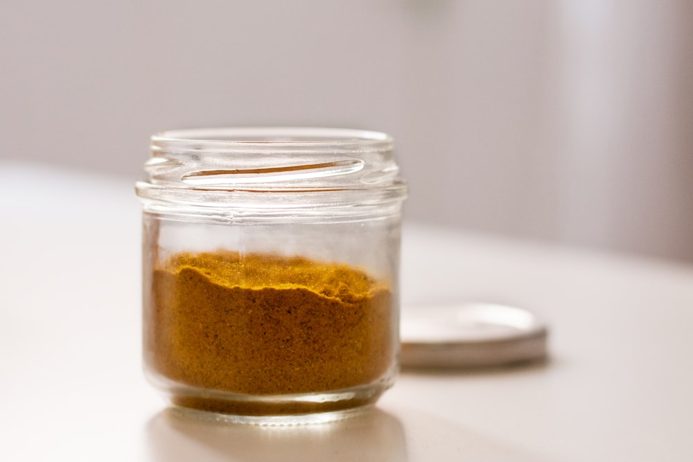 clear glass jar with brown powder
