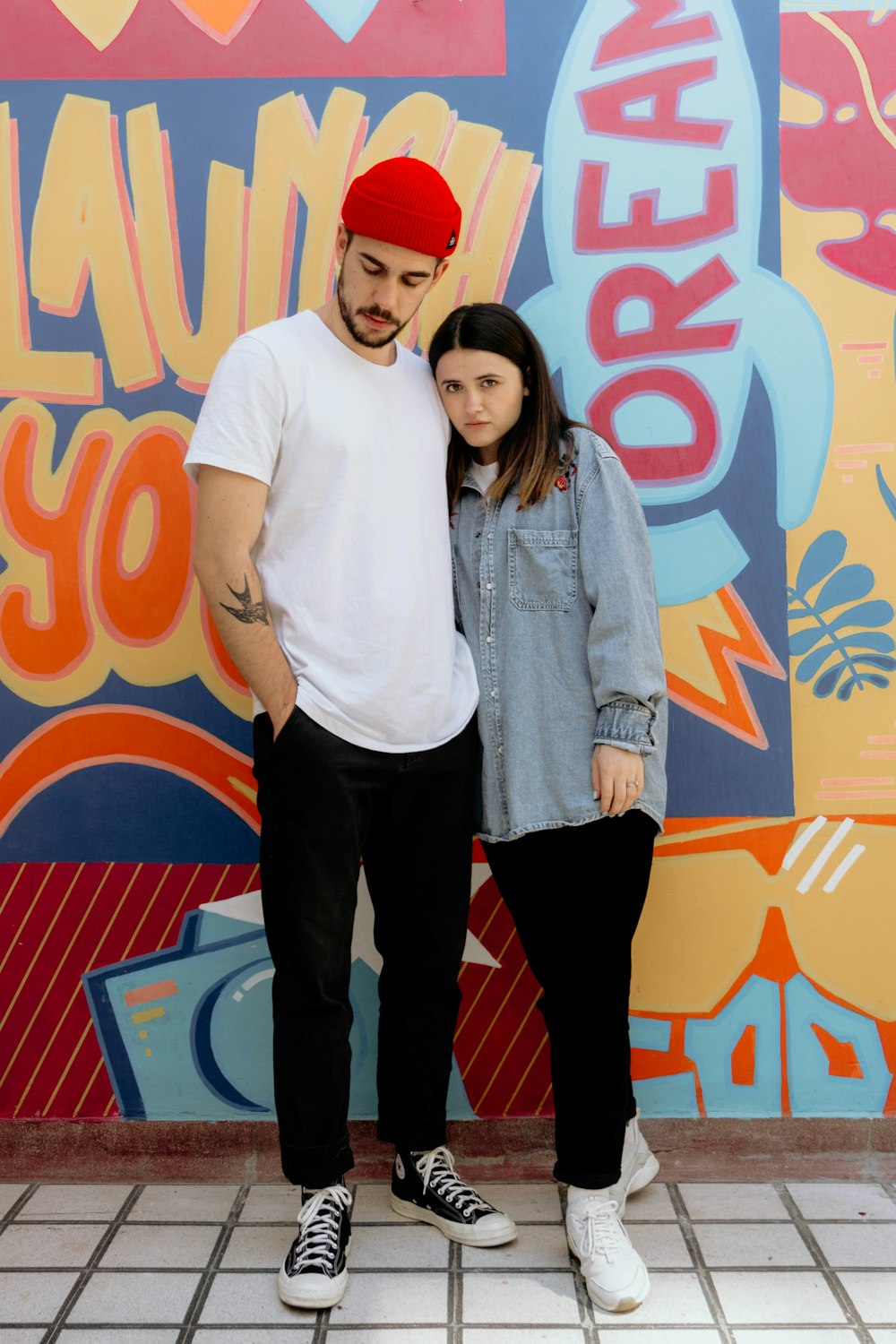 man in white button up shirt and black pants standing beside woman in white crew neck