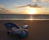 blue and white boat on beach during sunset