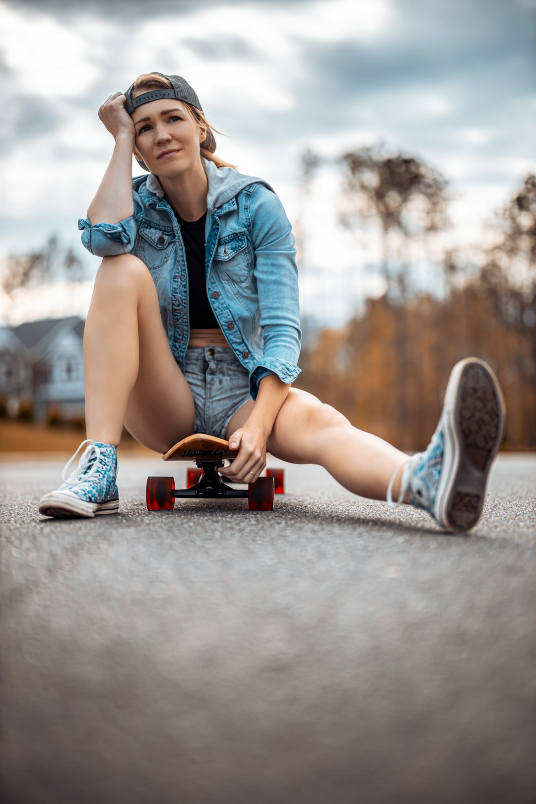 woman in blue denim jacket and blue denim shorts sitting on concrete floor