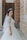 woman in white floral dress standing on gray concrete floor during daytime