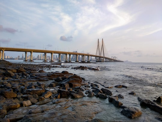 brown wooden bridge over the sea during daytime in Bandra Fort India