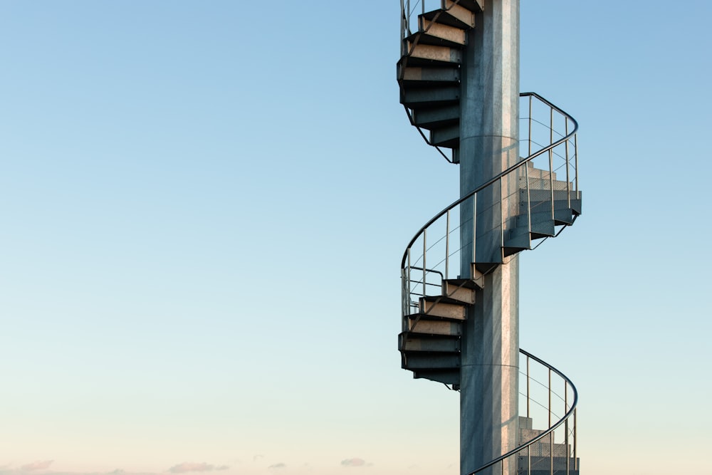 escada em espiral preta sob o céu azul durante o dia