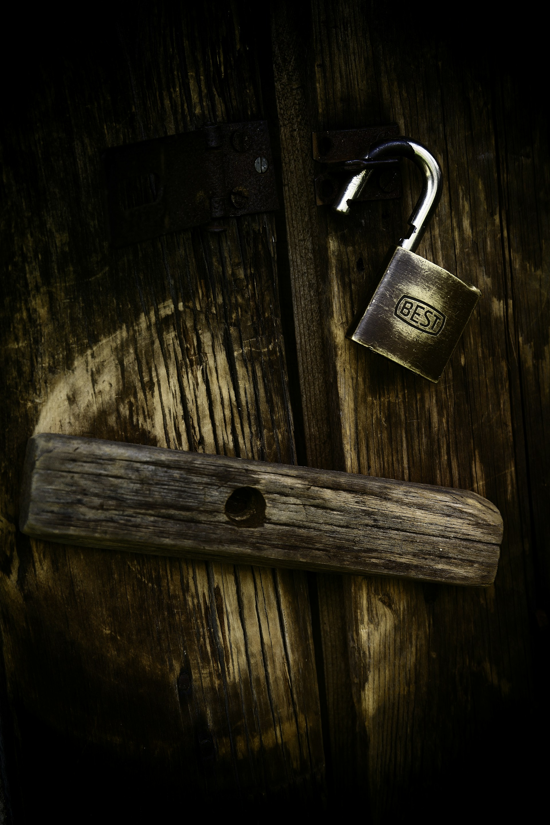 gold padlock on brown wooden surface
