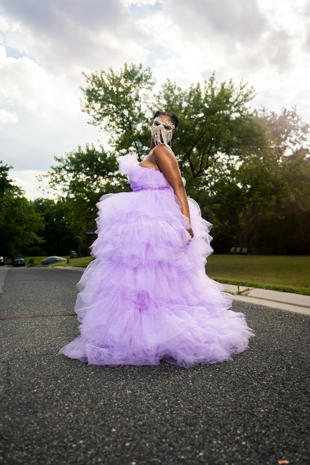 mulher no vestido cor-de-rosa que está na estrada de concreto cinzenta durante o dia