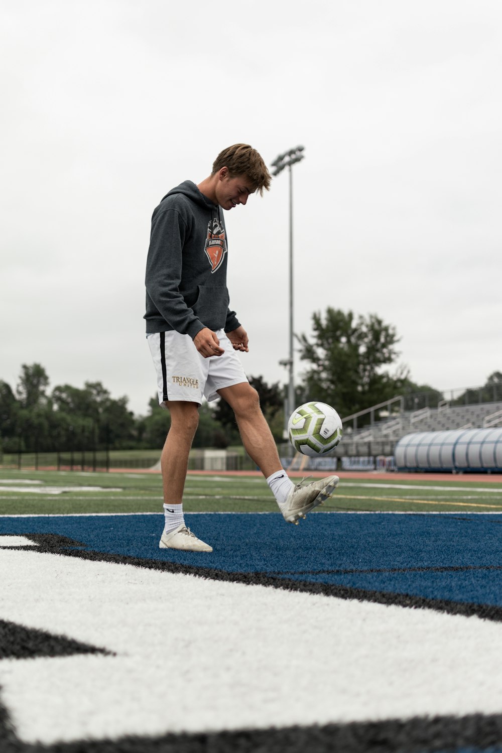 man in black long sleeve shirt and white shorts playing soccer during daytime