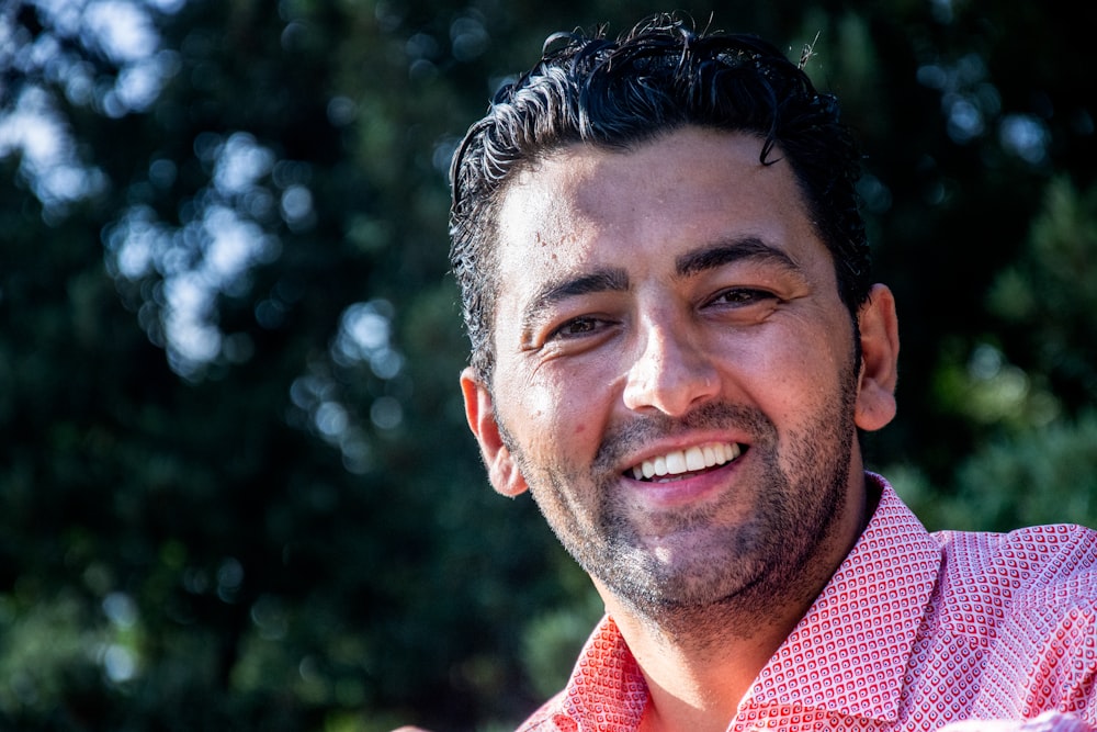 man in red and white checked collared shirt smiling