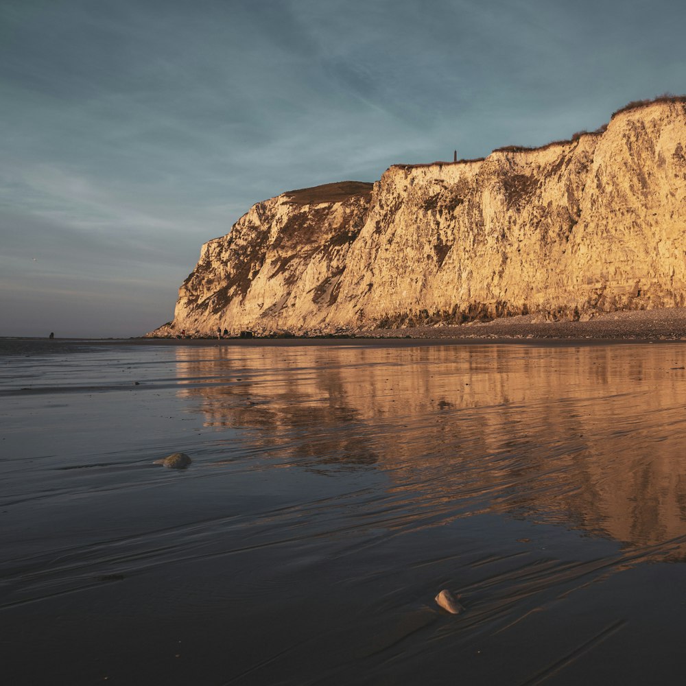 brown rock formation on body of water during daytime