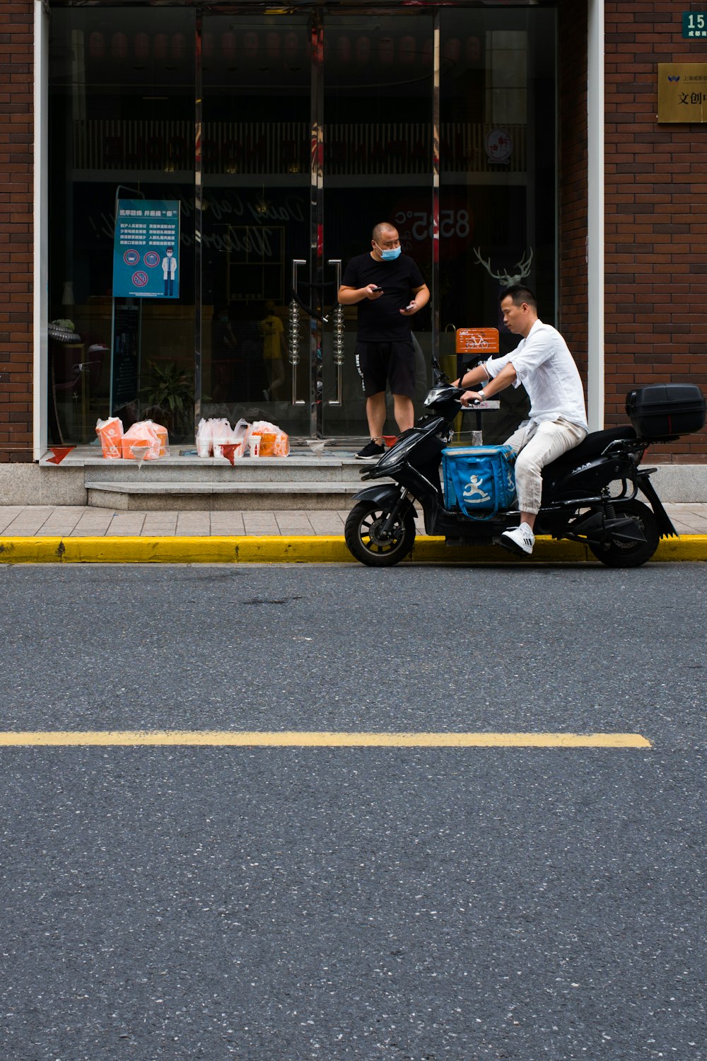 man in white shirt riding on black motorcycle