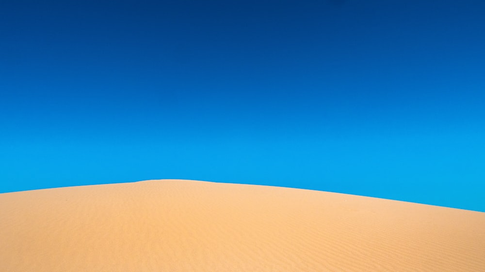 brown sand under blue sky during daytime