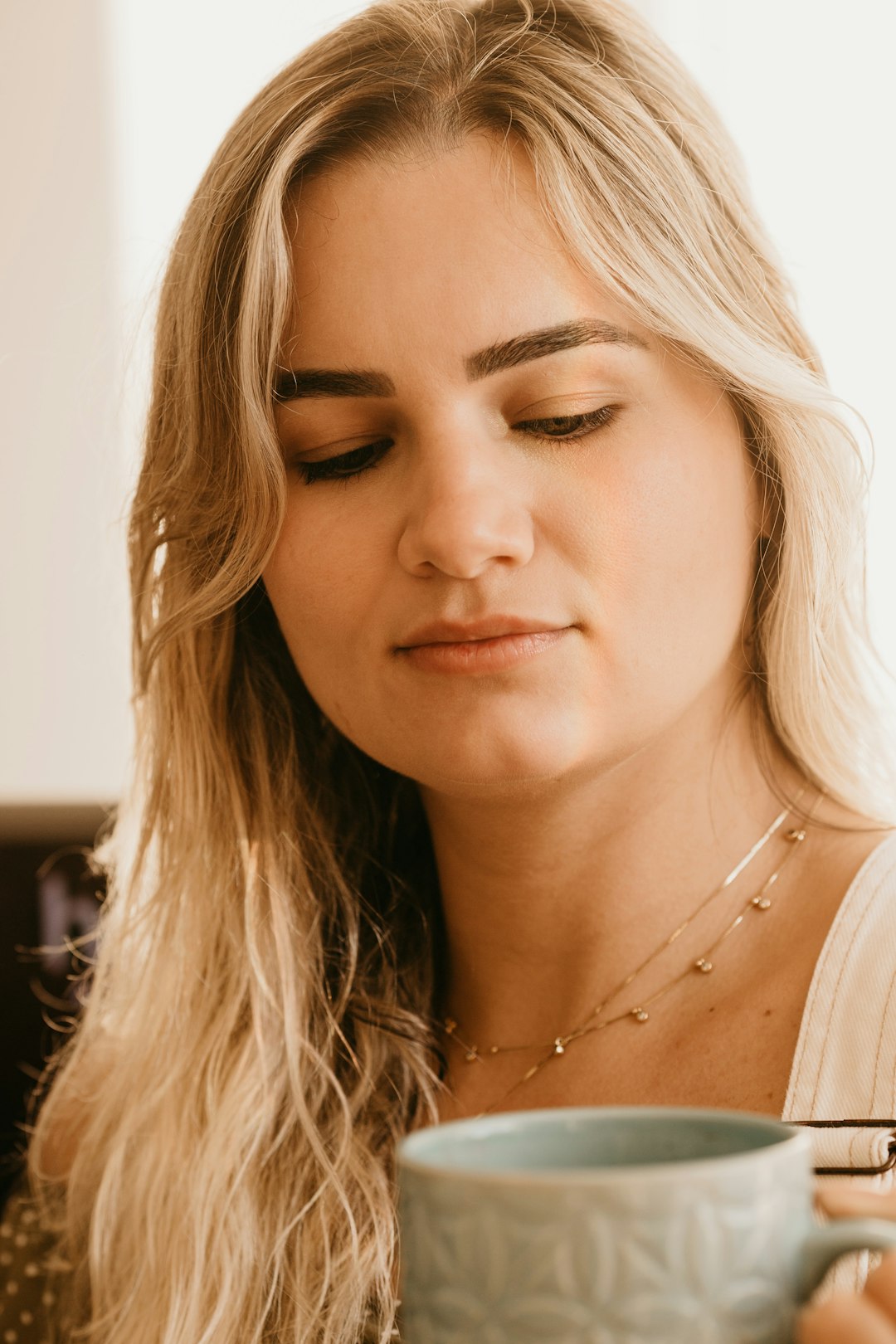 woman in white tank top wearing silver necklace