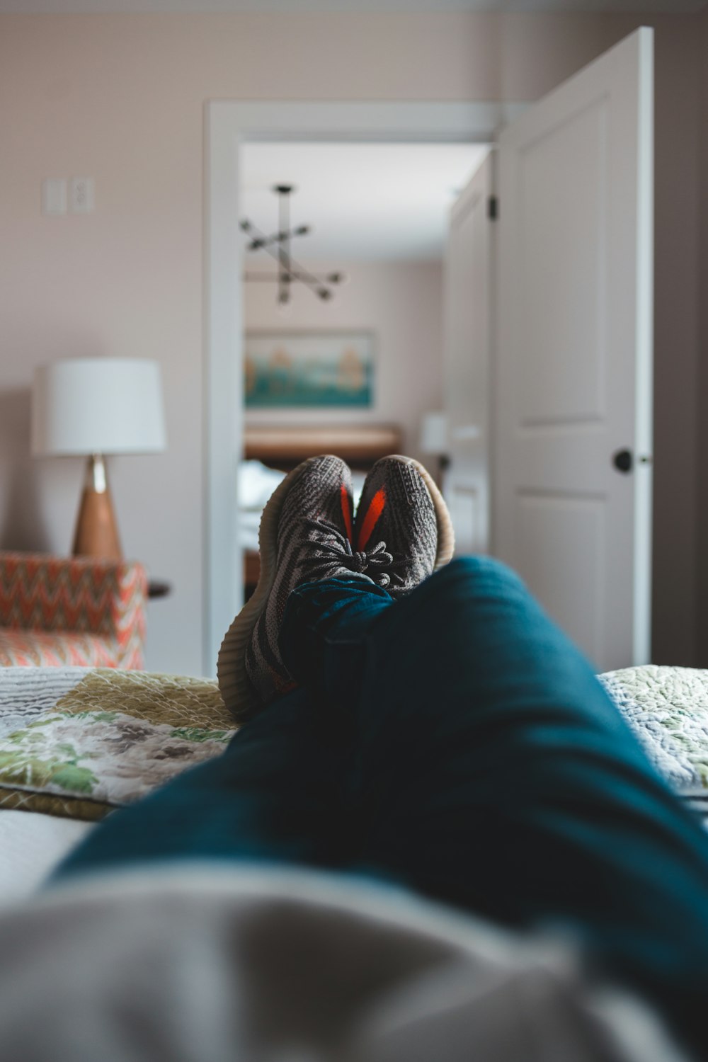 person in blue pants lying on bed