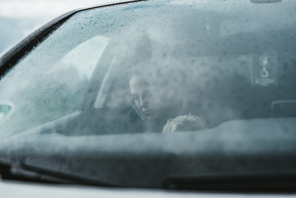 person in black jacket driving car