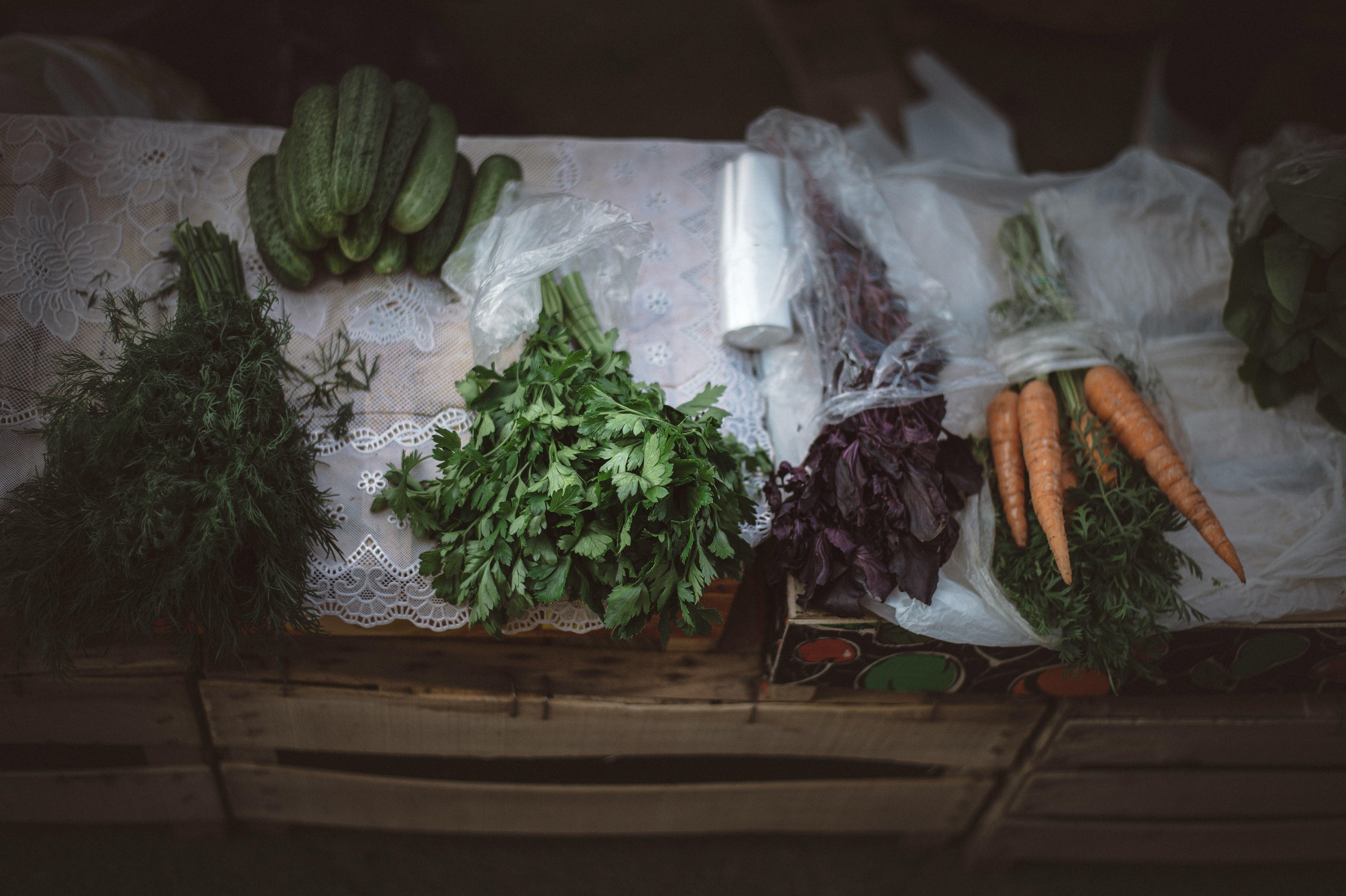 carrots and green vegetables on brown wooden table