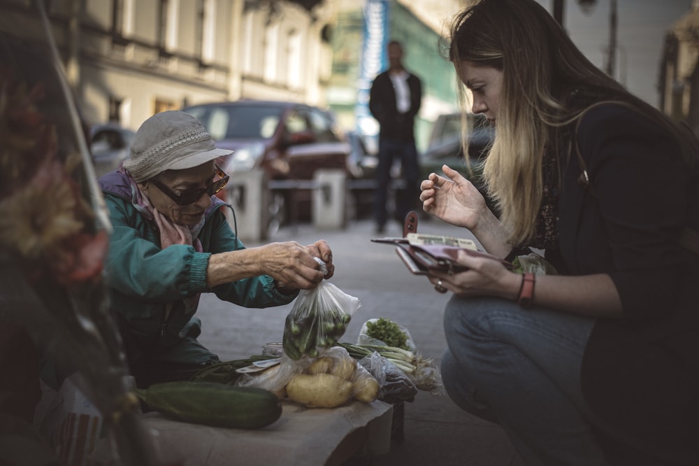 woman in blue denim jacket holding white smartphone