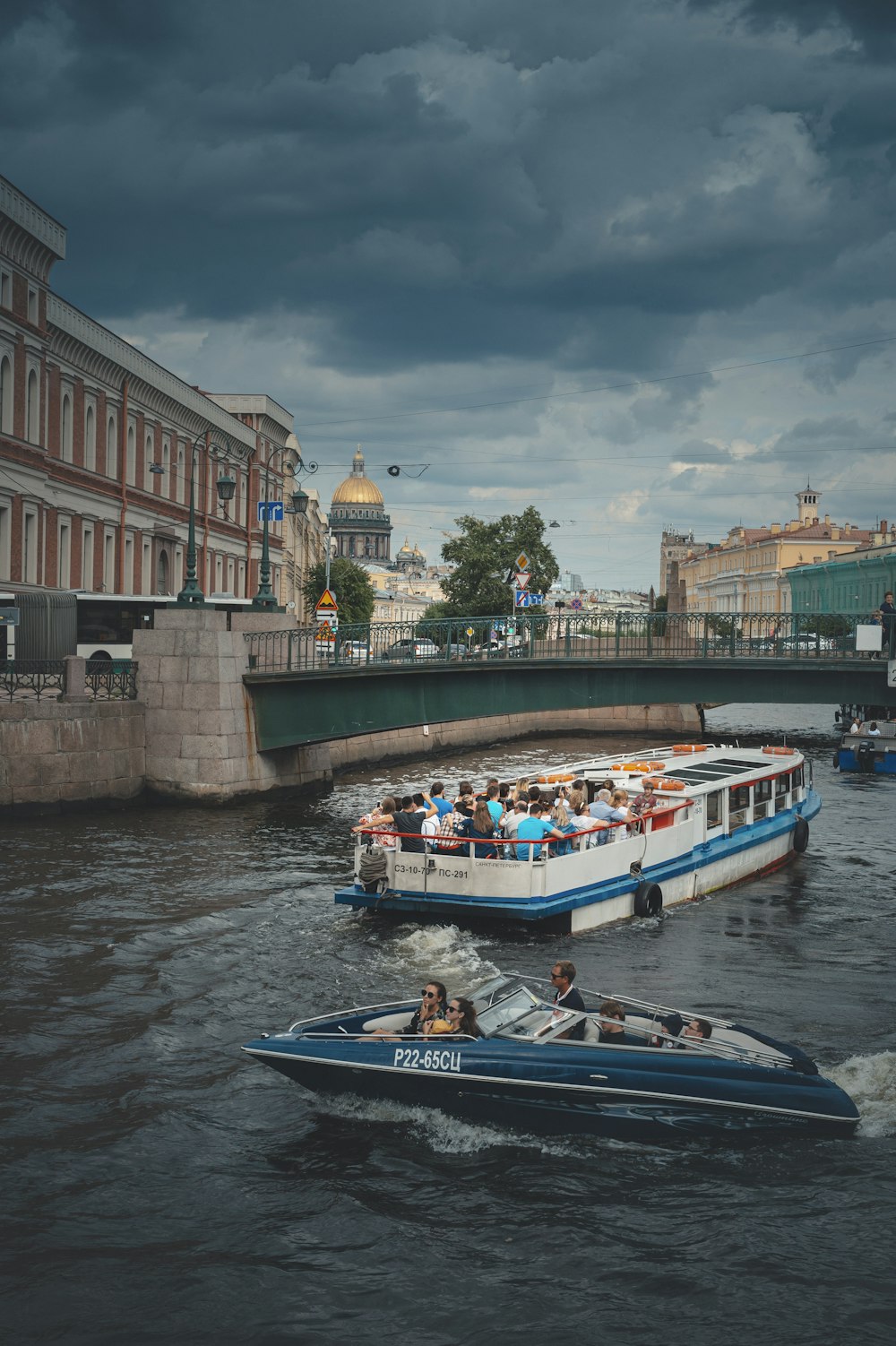 personas que viajan en botes azules y blancos en el río durante el día
