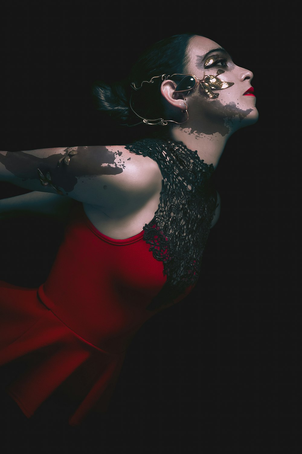 uma mulher em um vestido vermelho com tatuagens em seu braço