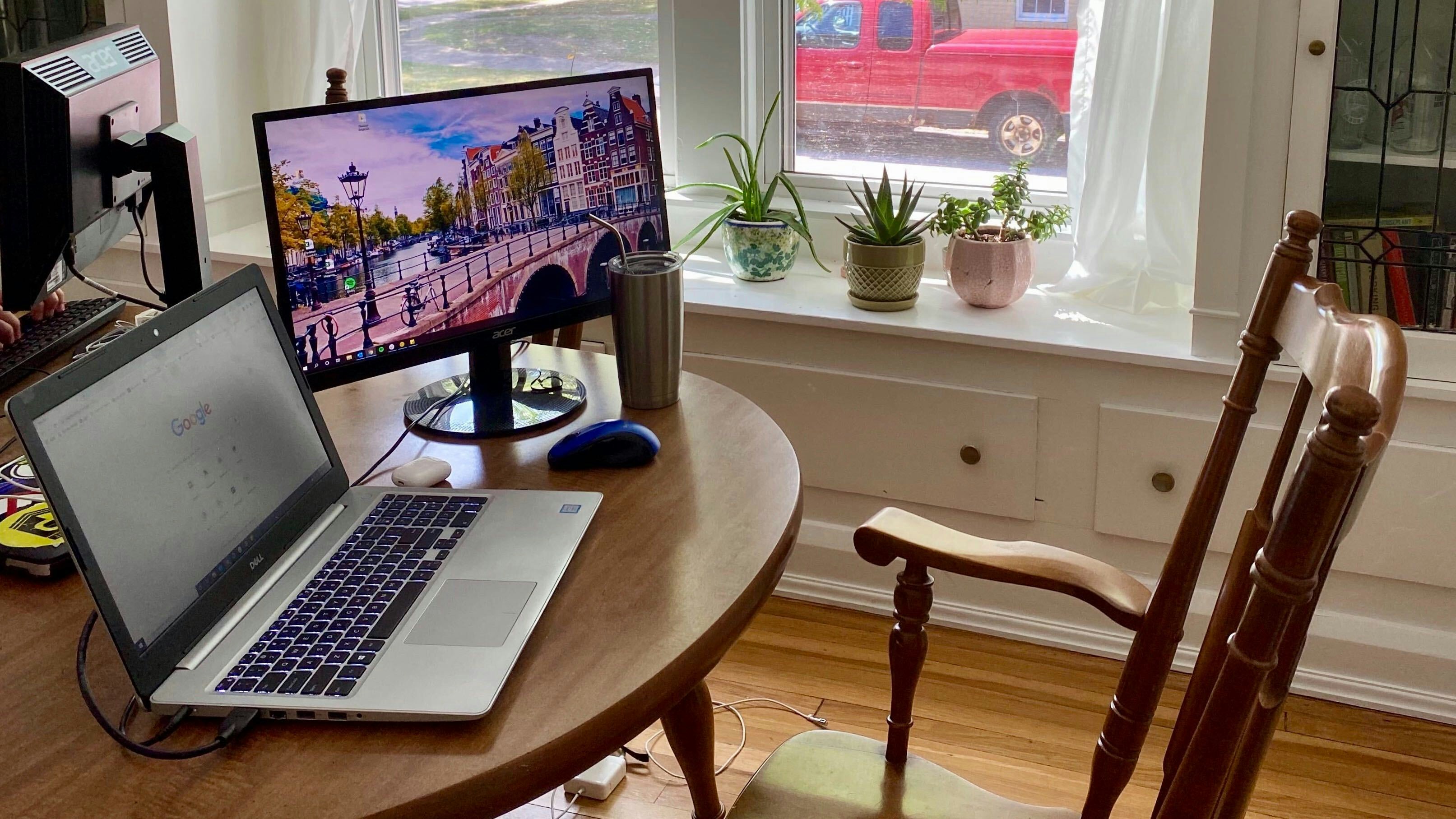 silver macbook pro on brown wooden table, Work from home setup in a dining room in Cleveland, OH by Emily Machovina
