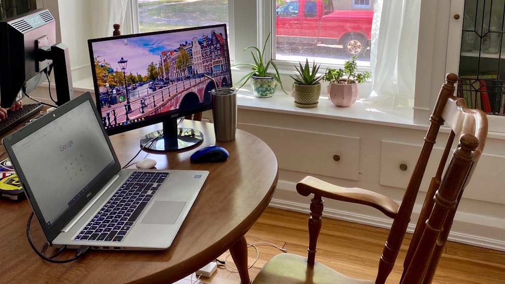 silver macbook pro on brown wooden table