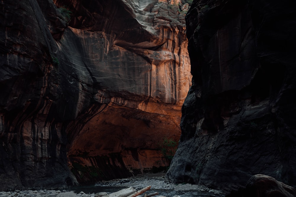 brown rocky mountain beside body of water during daytime