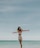 woman in white shorts standing on beach during daytime