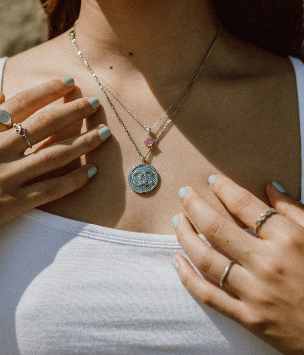 woman wearing silver necklace with round pendant