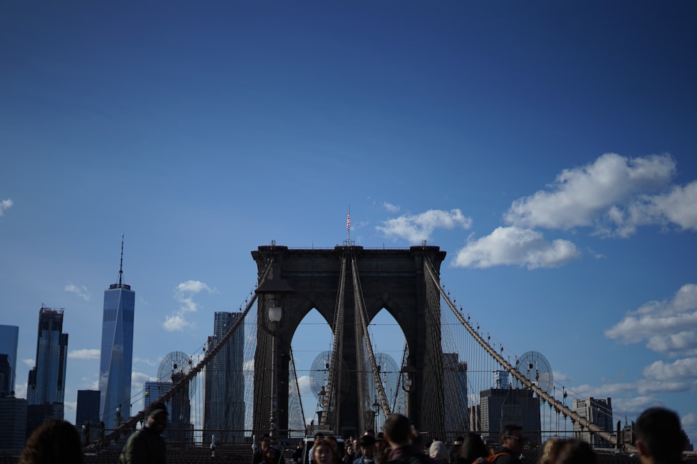 people walking on bridge under blue sky during daytime