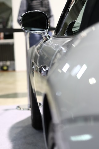 Close-up of a shiny car surface reflecting the workshop lights.