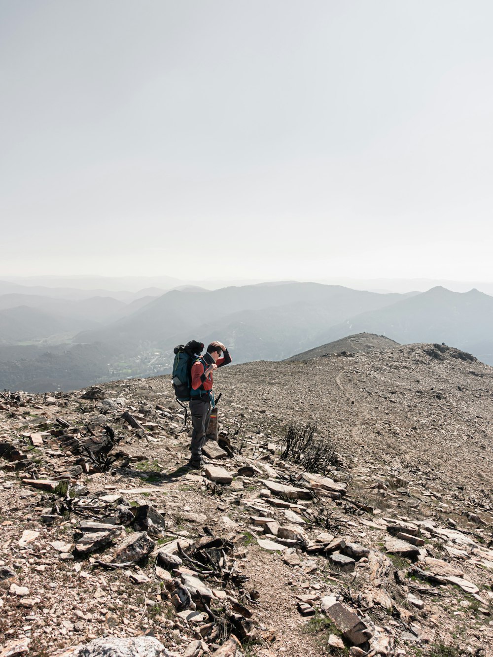 man in black jacket standing on rocky hill during daytime