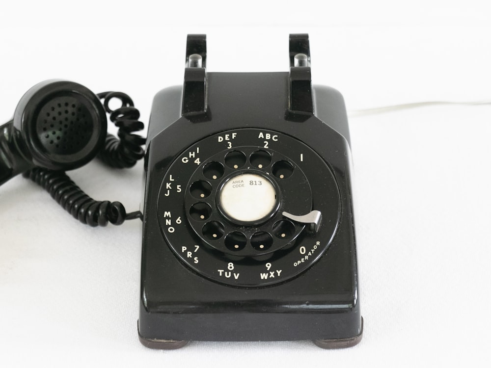 black rotary phone on white table