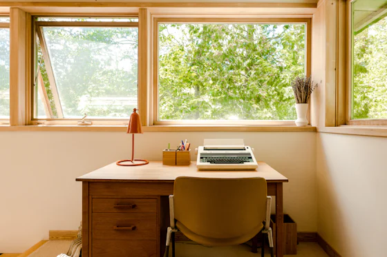 Laptop on a wooden desk used to research water heater warning signs