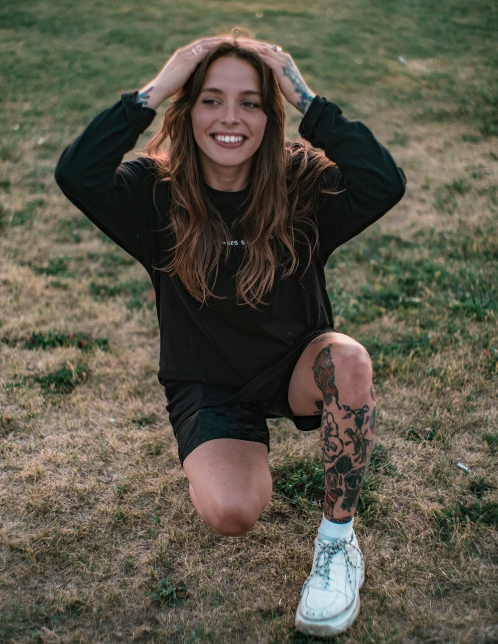 woman in black long sleeve shirt sitting on green grass field during daytime