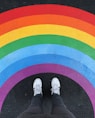 person in white pants and white sneakers standing on black and red carpet