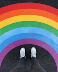 person in white pants and white sneakers standing on black and red carpet