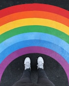 person in white pants and white sneakers standing on black and red carpet