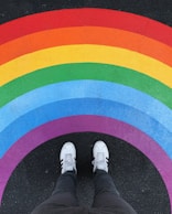 person in white pants and white sneakers standing on black and red carpet