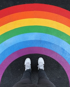 person in white pants and white sneakers standing on black and red carpet