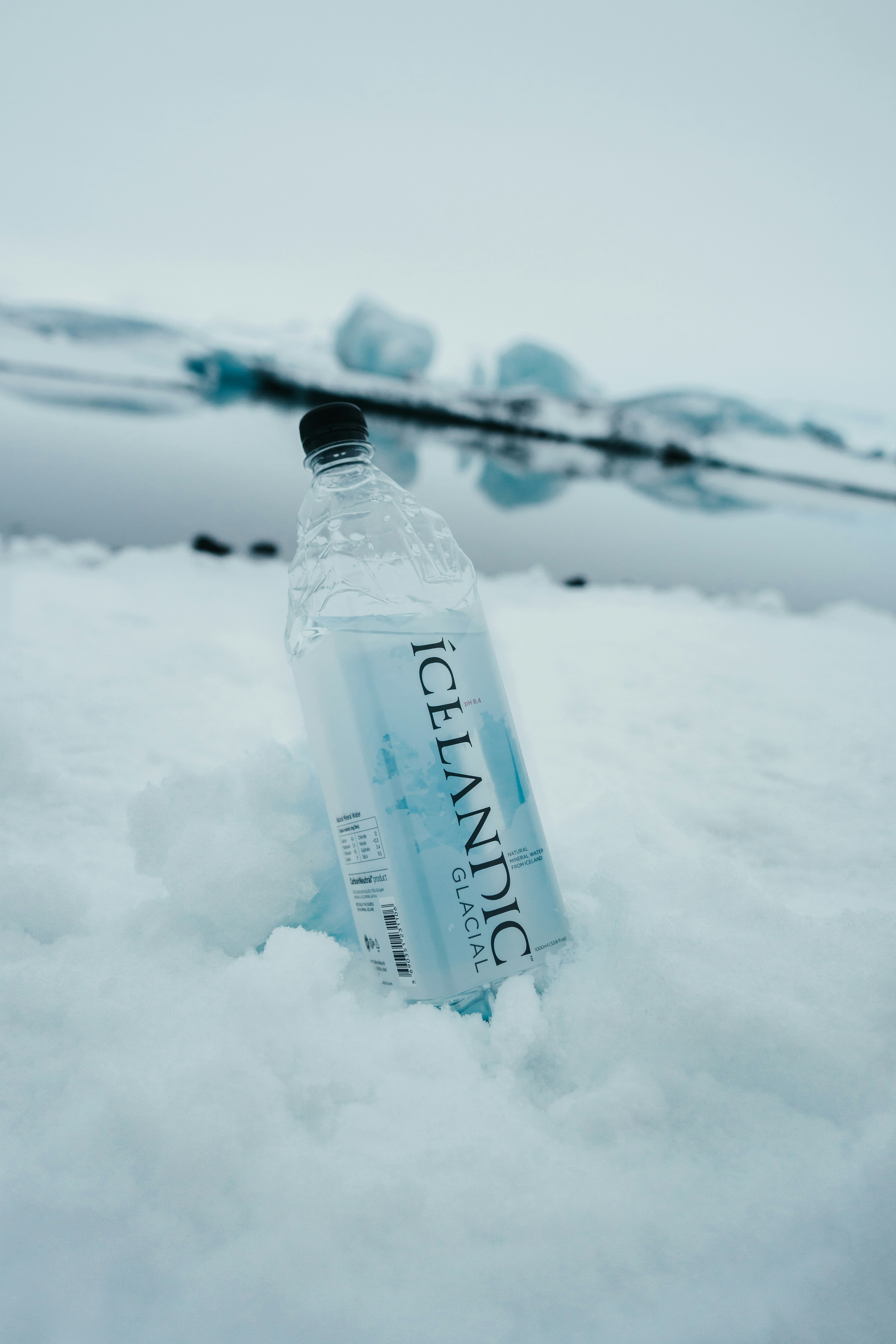 clear glass bottle on snow covered ground