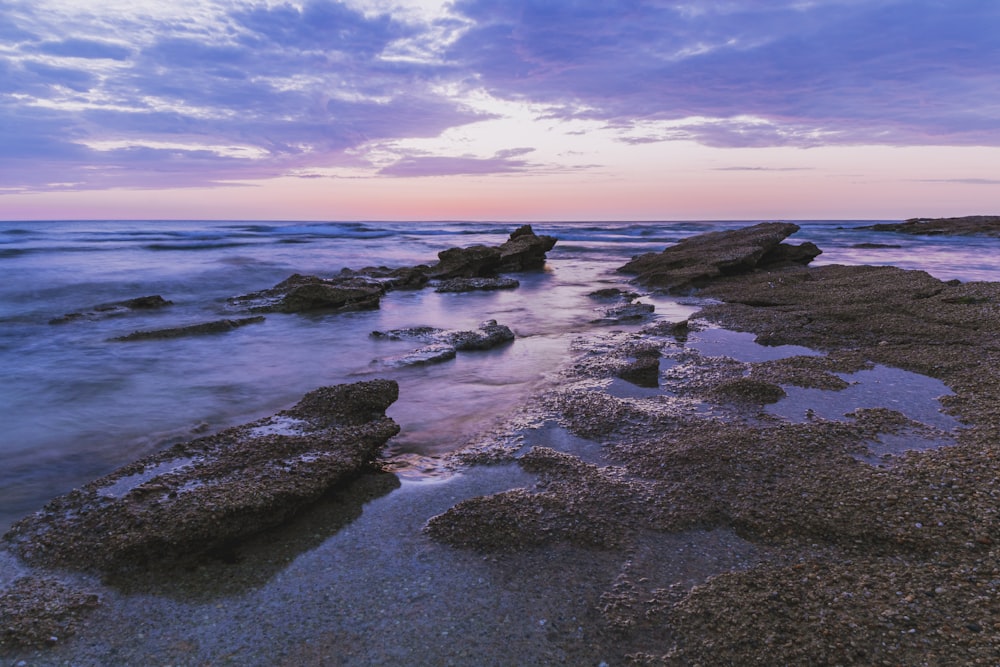 black rocks on sea shore during daytime