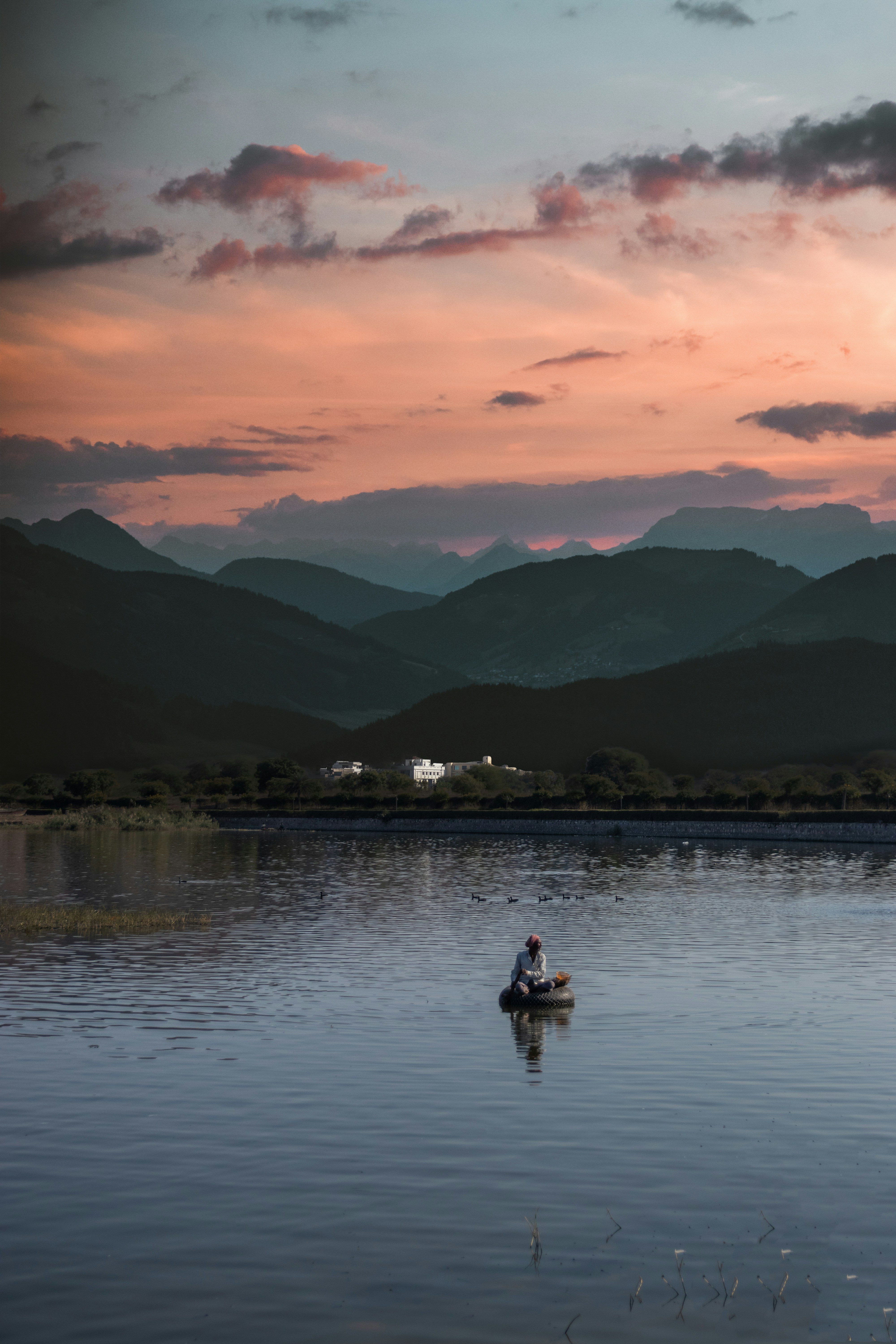 2 people on lake during sunset