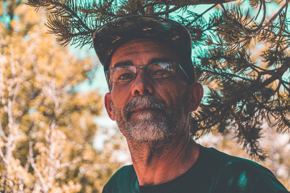 man in green crew neck shirt wearing black cap