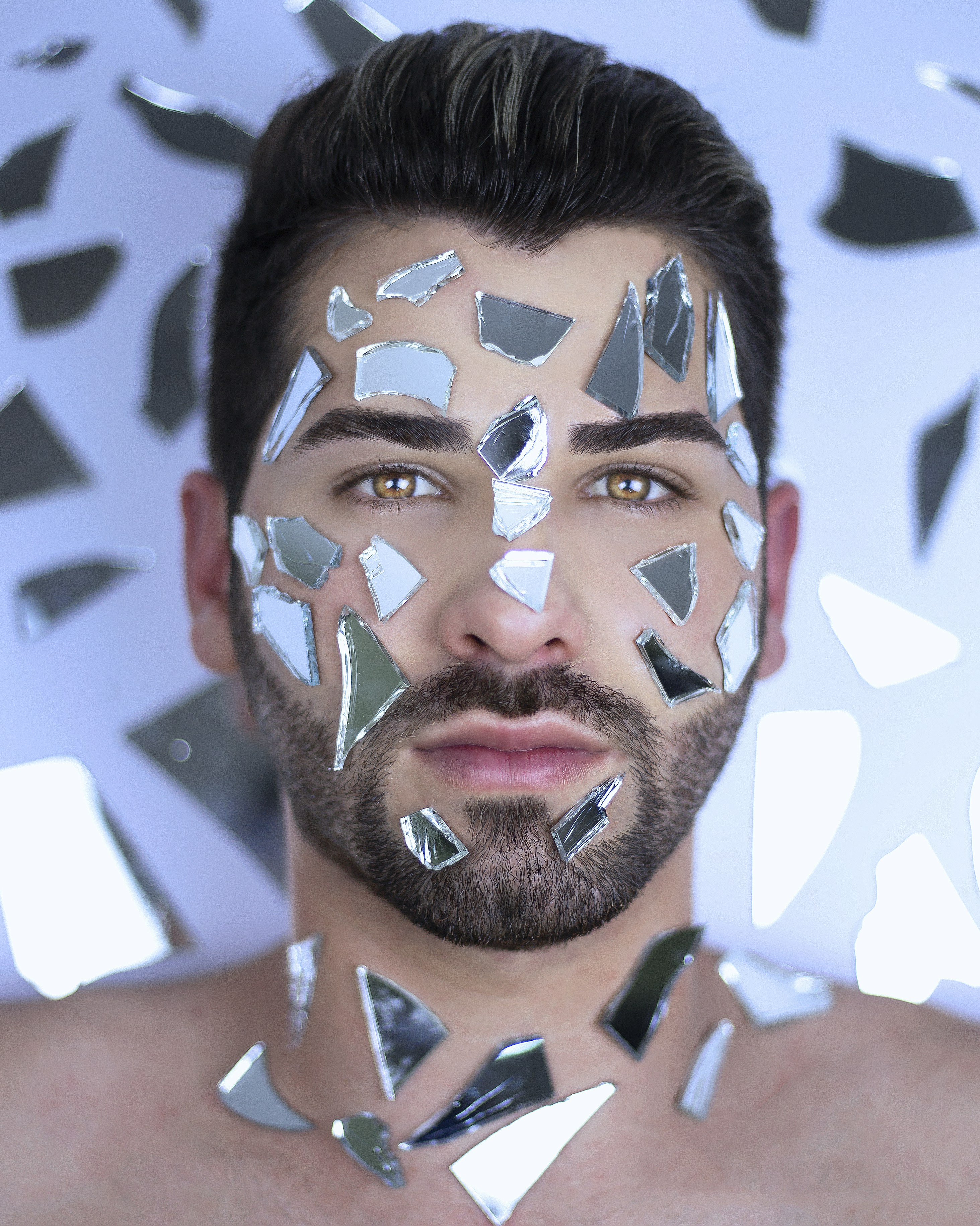 A symbolic image of shattered glass overlaying a human face, representing the loss of identity and truth